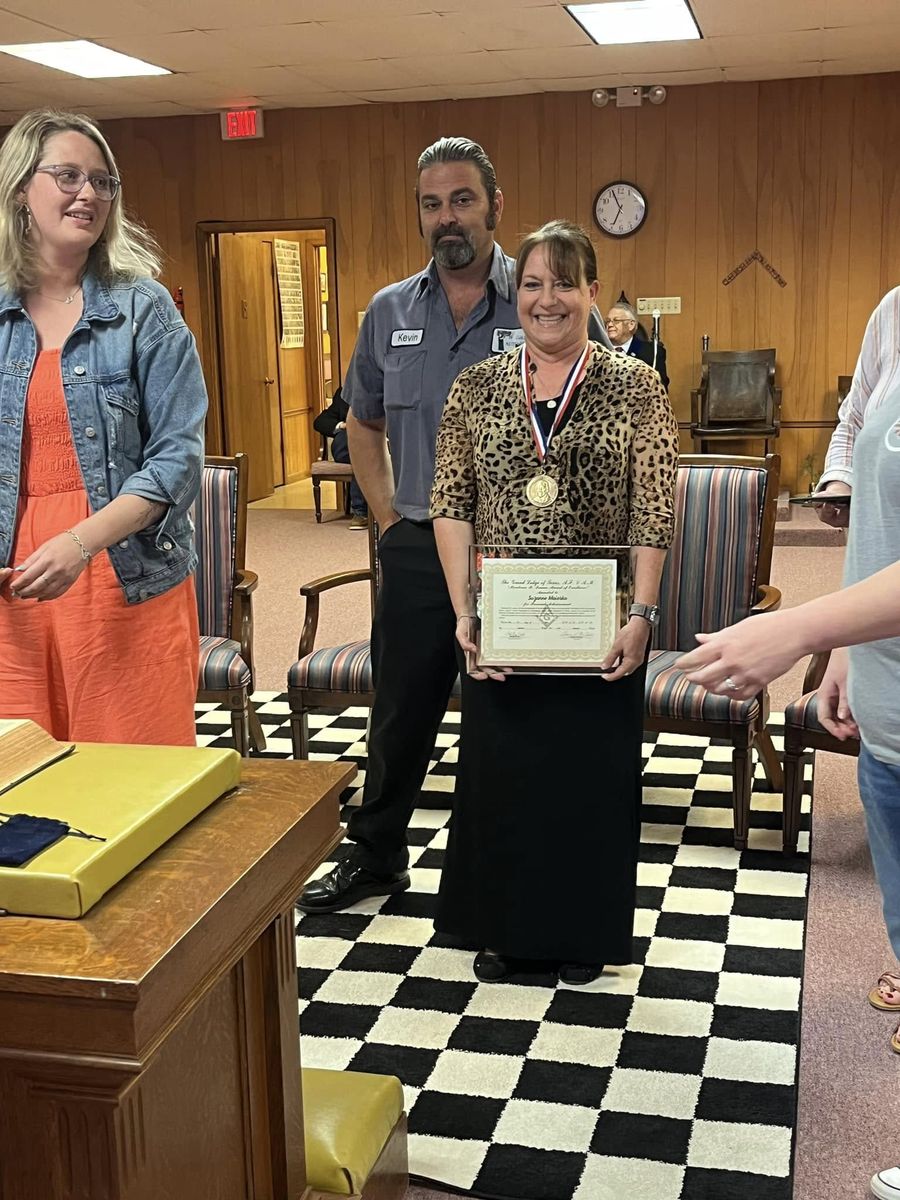 A Lamar Medal recipient wearing her medal and holding her Mirabeau B. Lamar Award of Excellence certificate